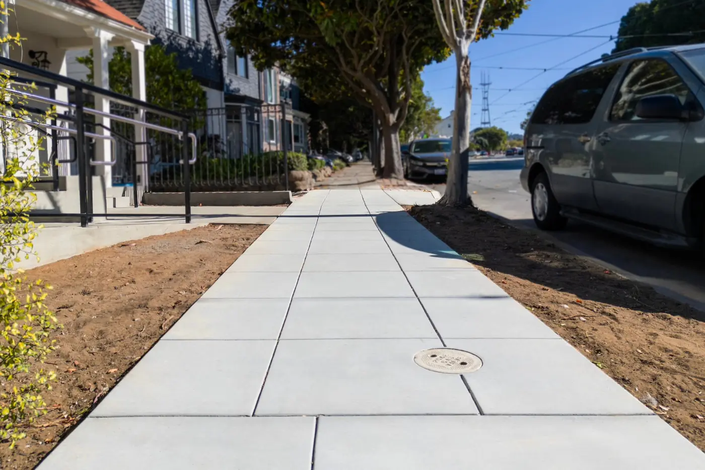 Low-angle along fresh sidewalk panel, tooled joints — ADA Ramp & Sidewalk — West Portal, West Portal, San Francisco