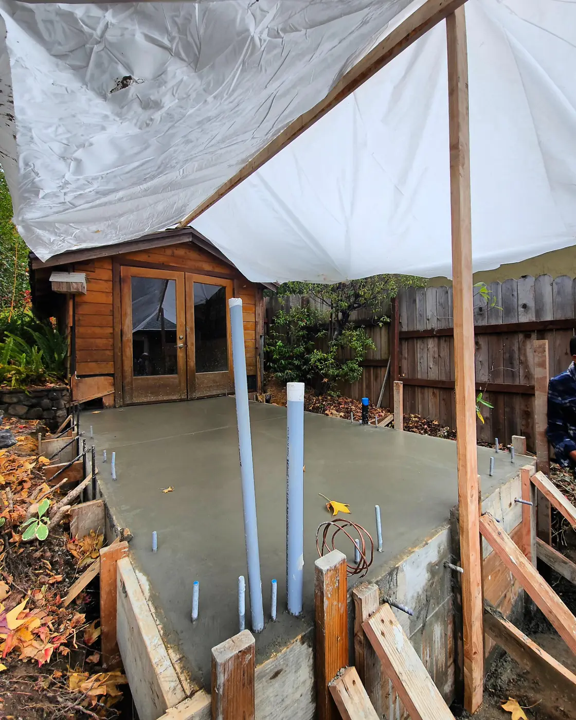 Poured slab under rain tarp — Backyard ADU Foundation, San Rafael, CA