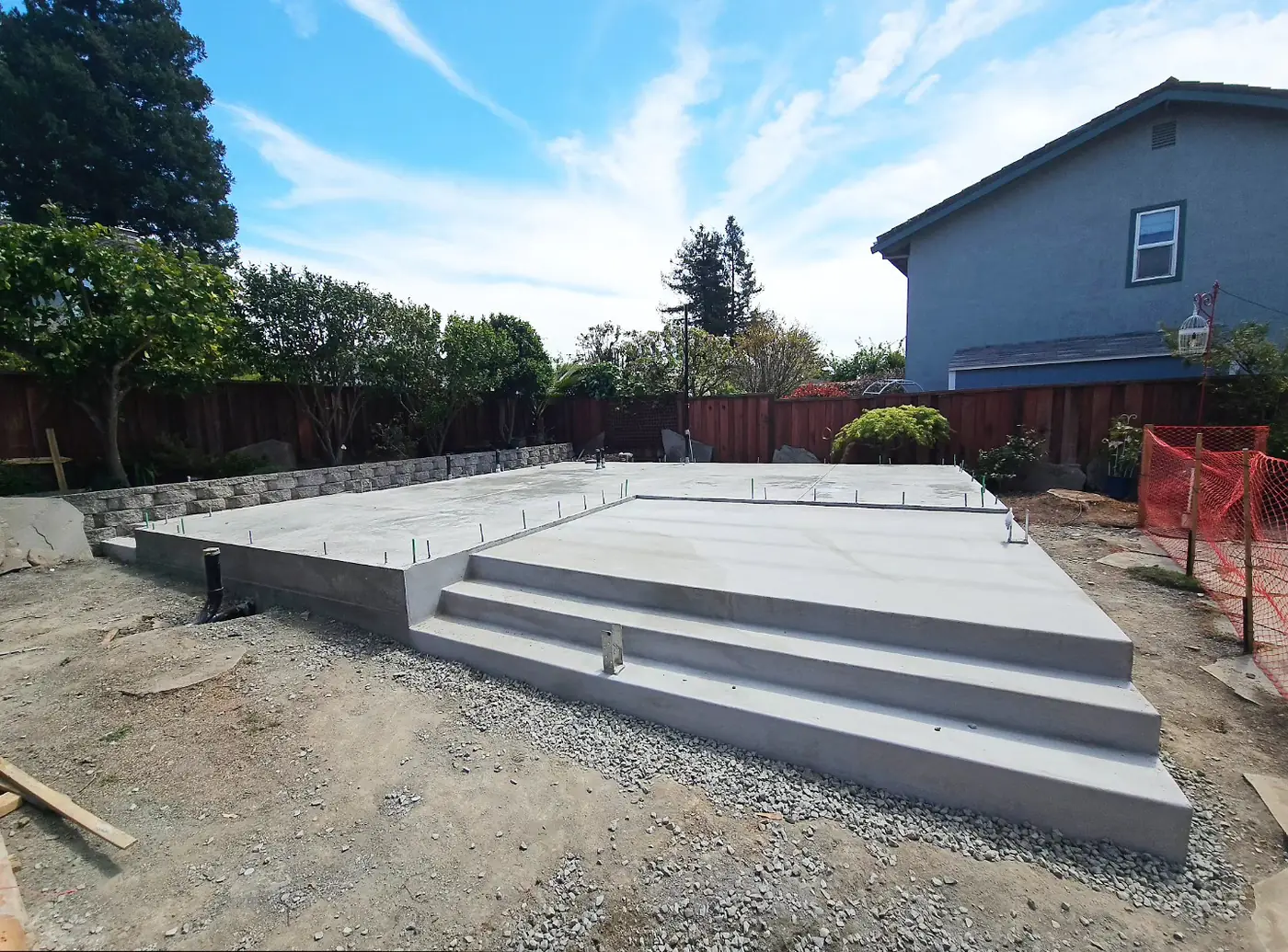 Completed ADU slab, smooth finish, anchor bolts, stepped entry, gravel surround — Pleasanton ADU Foundation, Pleasanton, CA