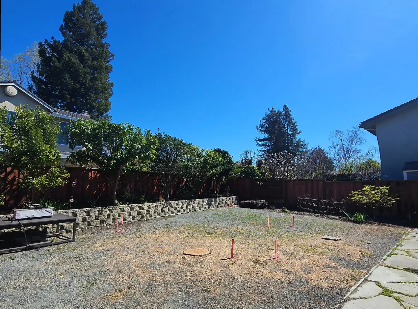 Pre-construction site, survey stakes, block wall behind — Pleasanton ADU Foundation, Pleasanton, CA