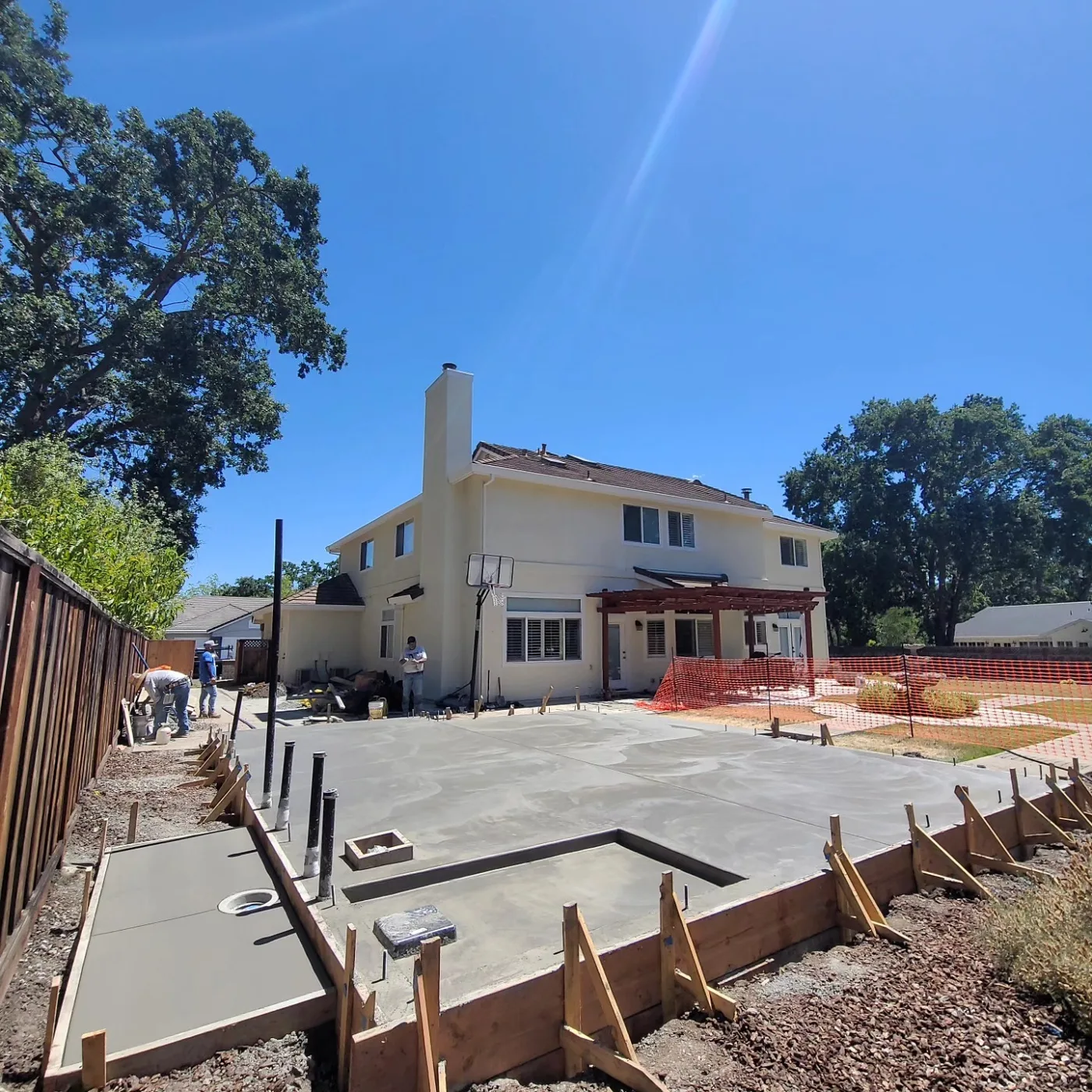 Placing and finishing the wet concrete slab and patio, main house behind — Alamo ADU Foundation, Alamo, CA