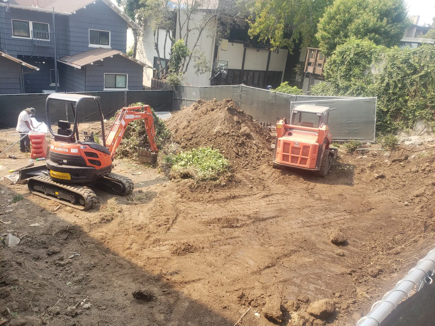 Mass excavation with an excavator and skid-steer, homes alongside — Berkeley Student Housing Foundation, Berkeley, CA