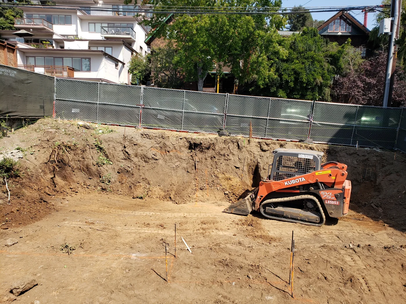 Skid-steer cutting into the deep basement excavation — Berkeley Student Housing Foundation, Berkeley, CA