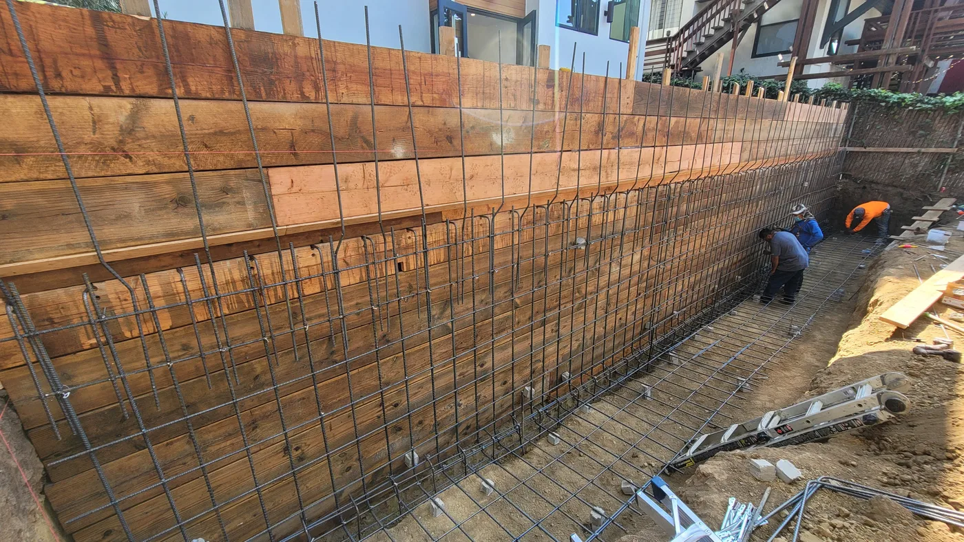 Tall board-formed retaining wall with rebar and shoring — Berkeley Student Housing Foundation, Berkeley, CA