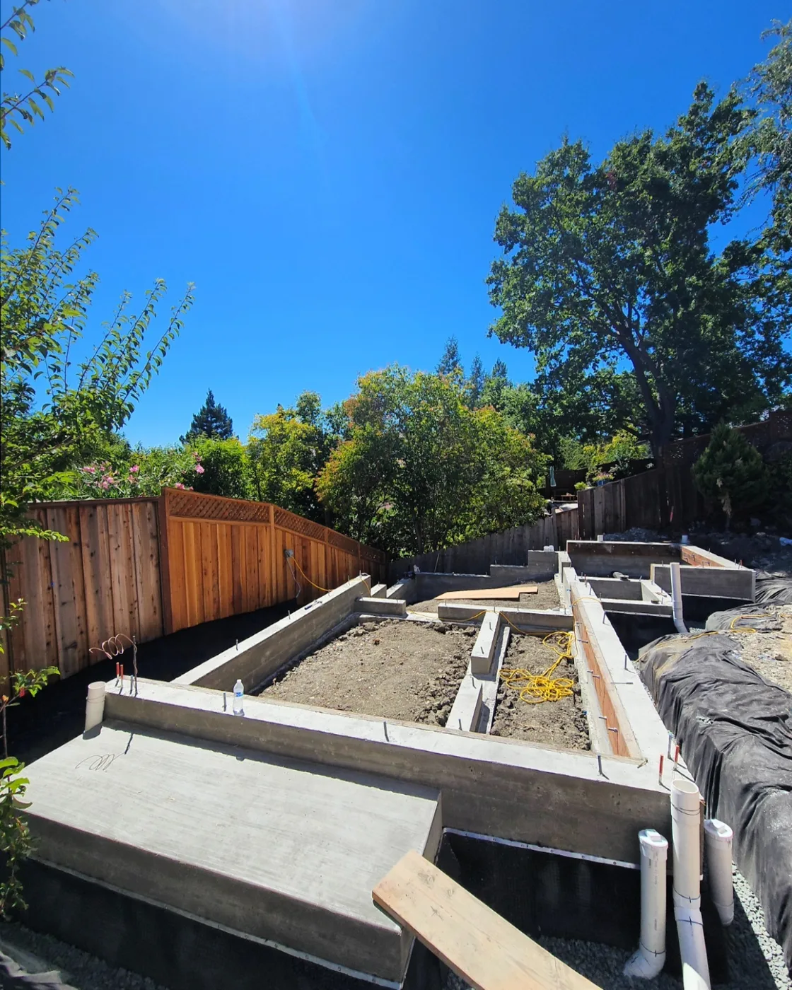Forms stripped — finished stem walls with dimple-board waterproofing and the poured entry pad — Danville ADU Foundation, Danville, CA