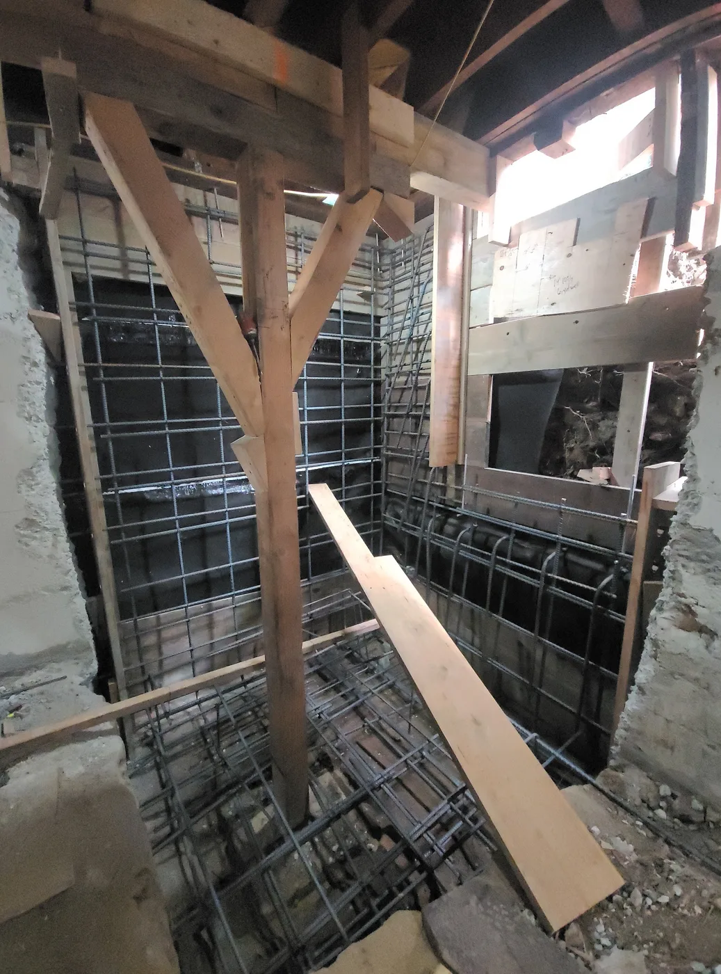 Rebar cage for a new basement wall rising inside the shored structure — Durant Basement Foundation, Berkeley, CA