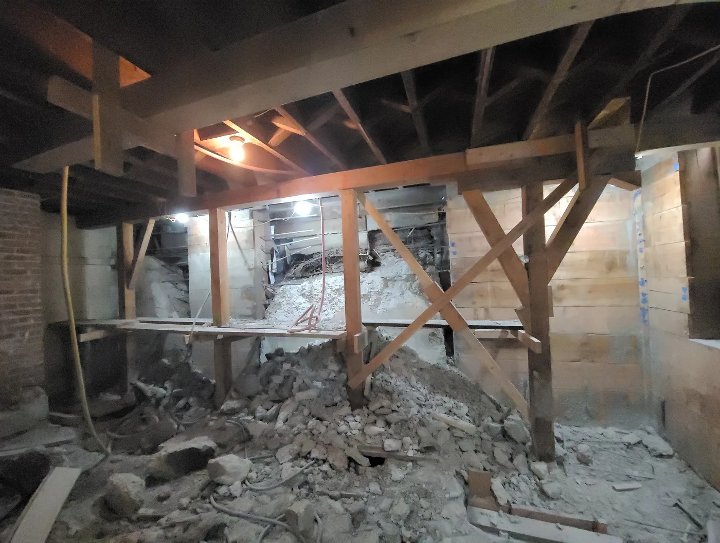 Excavation underway beneath the building, temporary shoring carrying the floors above — Durant Basement Foundation, Berkeley, CA