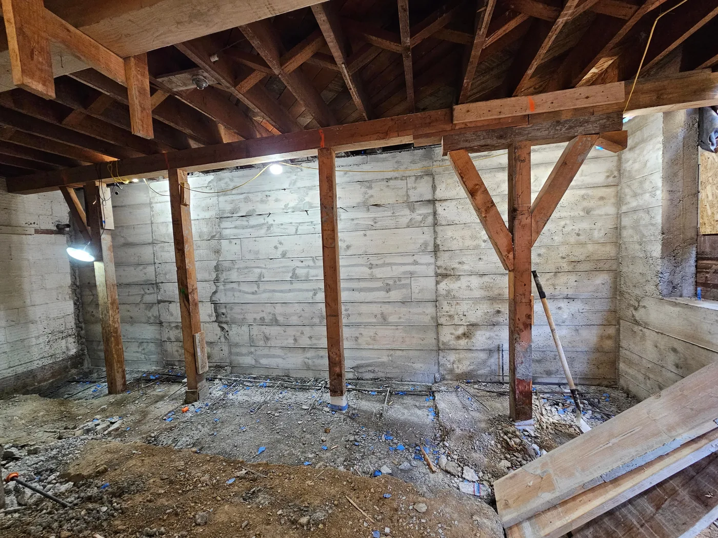 New poured concrete basement wall stripped of forms, shoring still in place — Durant Basement Foundation, Berkeley, CA