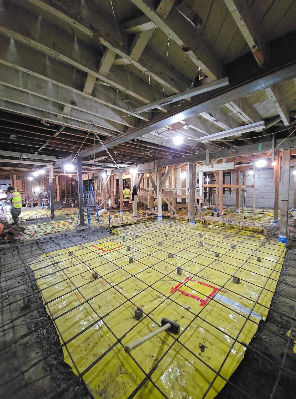 Slab reinforcement laid out beneath the shored floor structure above — Durant Basement Foundation, Berkeley, CA