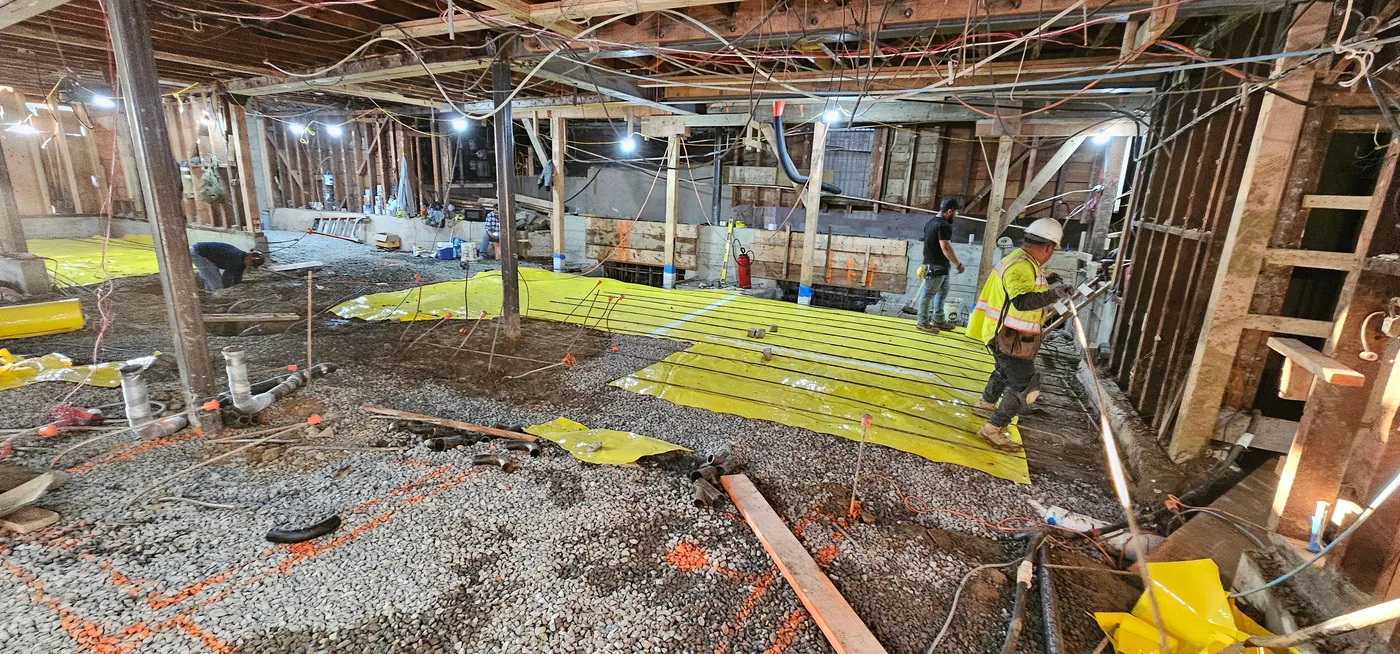 Crew placing vapor barrier and slab rebar across the basement — Durant Basement Foundation, Berkeley, CA