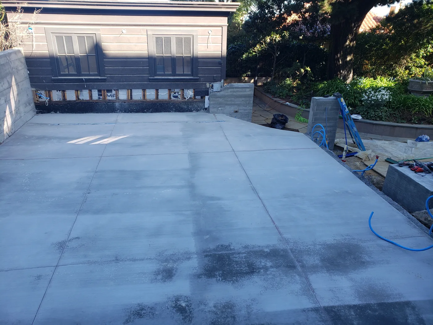 Finished concrete court slab, smooth and paint-ready, framed by the retaining walls — Lombard Street Basketball Court Foundation, San Francisco, CA