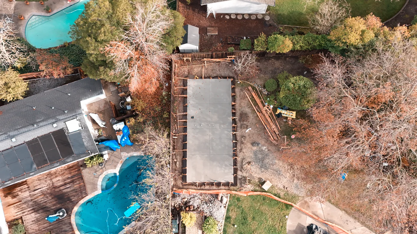 Slab-on-grade: a freshly poured ADU slab curing in its forms — Moraga