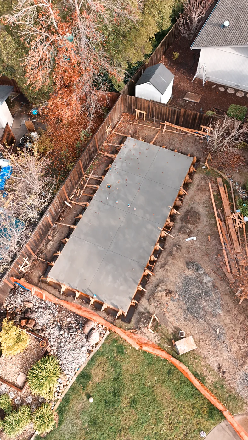 Aerial of the poured slab in its forms between the fence line and the neighboring yards   — Moraga Backyard ADU, Moraga, CA