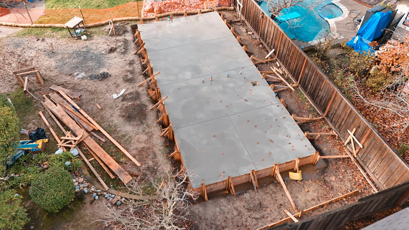 Aerial of the finished pour with anchor bolts and plumbing stub-ups set in the slab — Moraga Backyard ADU, Moraga, CA