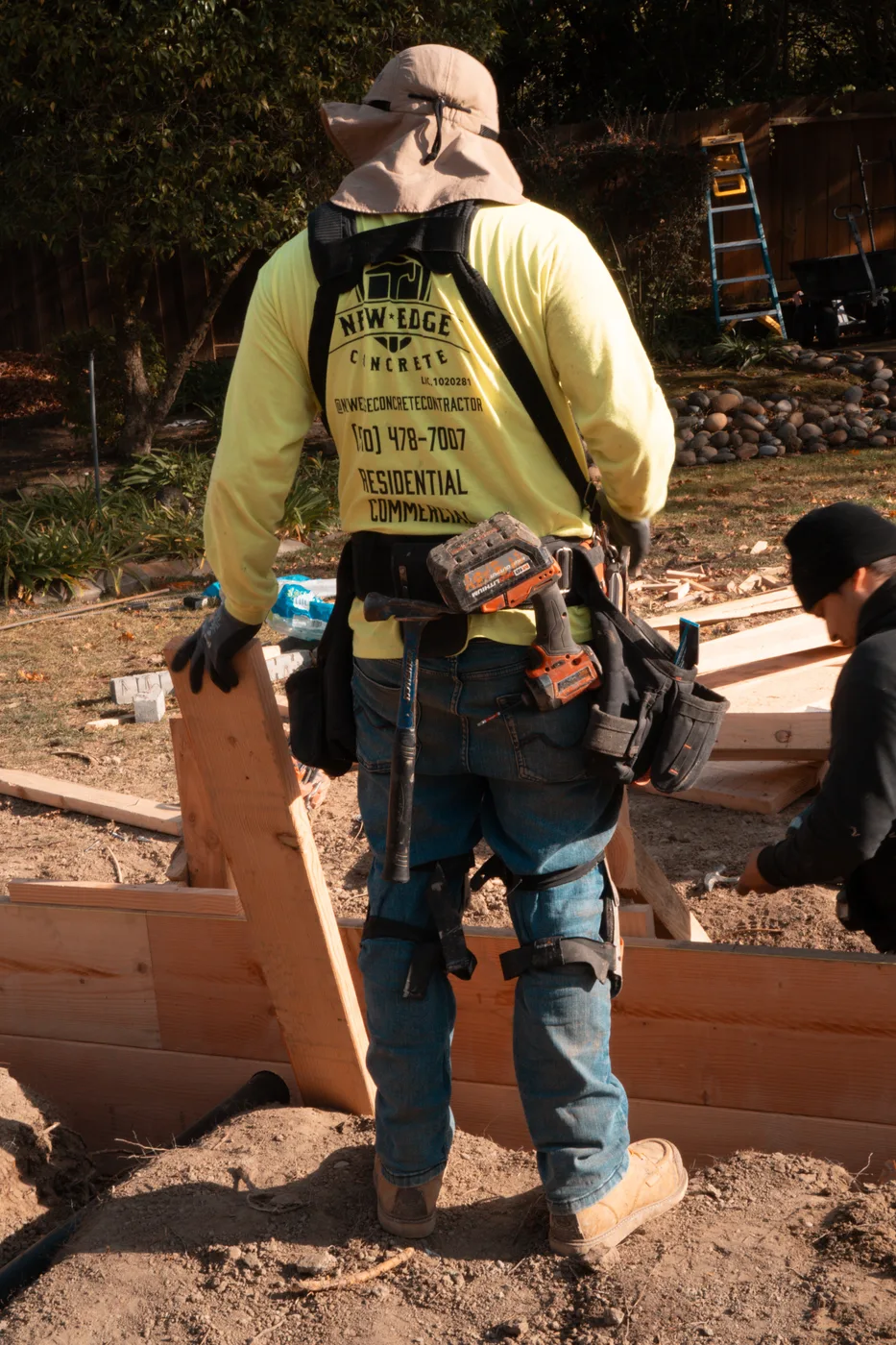New Edge Concrete crew member with tool belt at the formed footprint — Moraga Backyard ADU, Moraga, CA