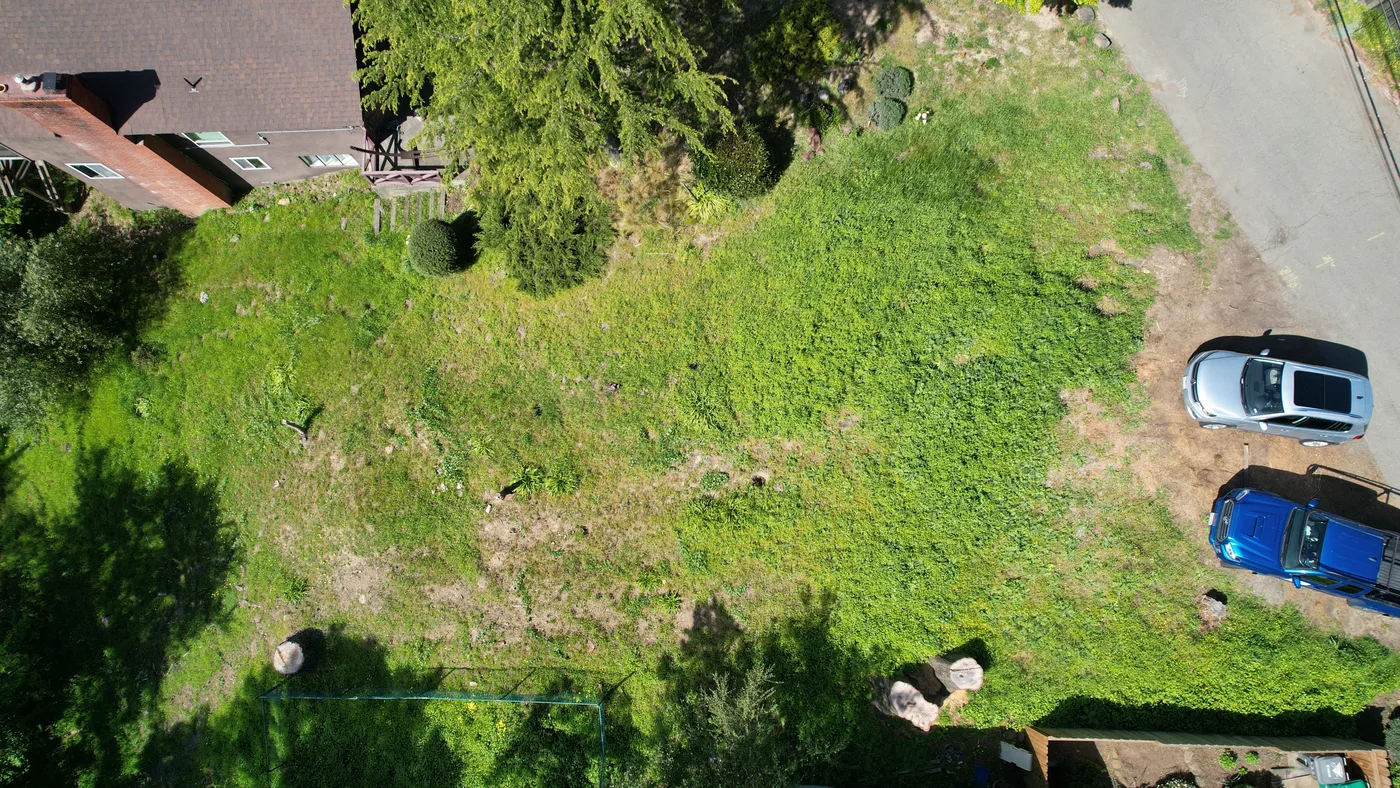 BEFORE: aerial of the green hillside lot before excavation — Oakland Hills Custom Home, Oakland, CA