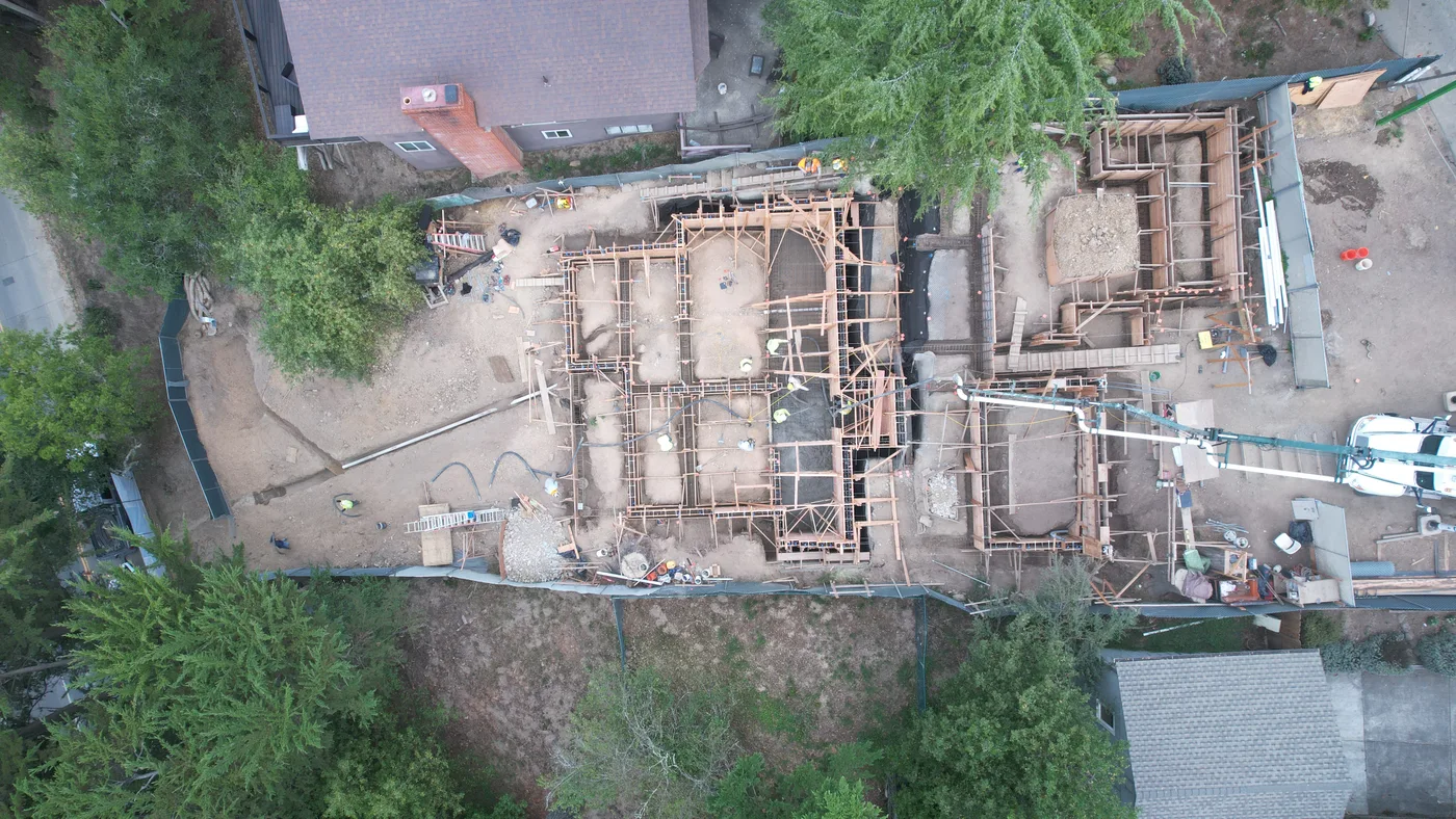 Top-down aerial of the formed foundation with concrete pump lines — Oakland Hills Custom Home, Oakland, CA