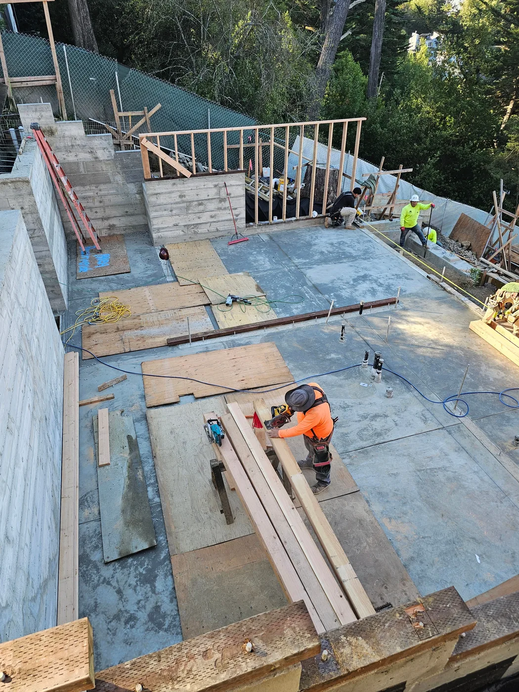 Poured concrete slab and walls, worker for scale — Oakland Hills Custom Home, Oakland, CA