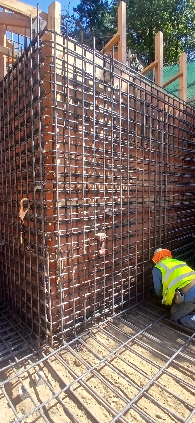Worker tying a tall rebar wall cage — Oakland Hills Custom Home, Oakland, CA