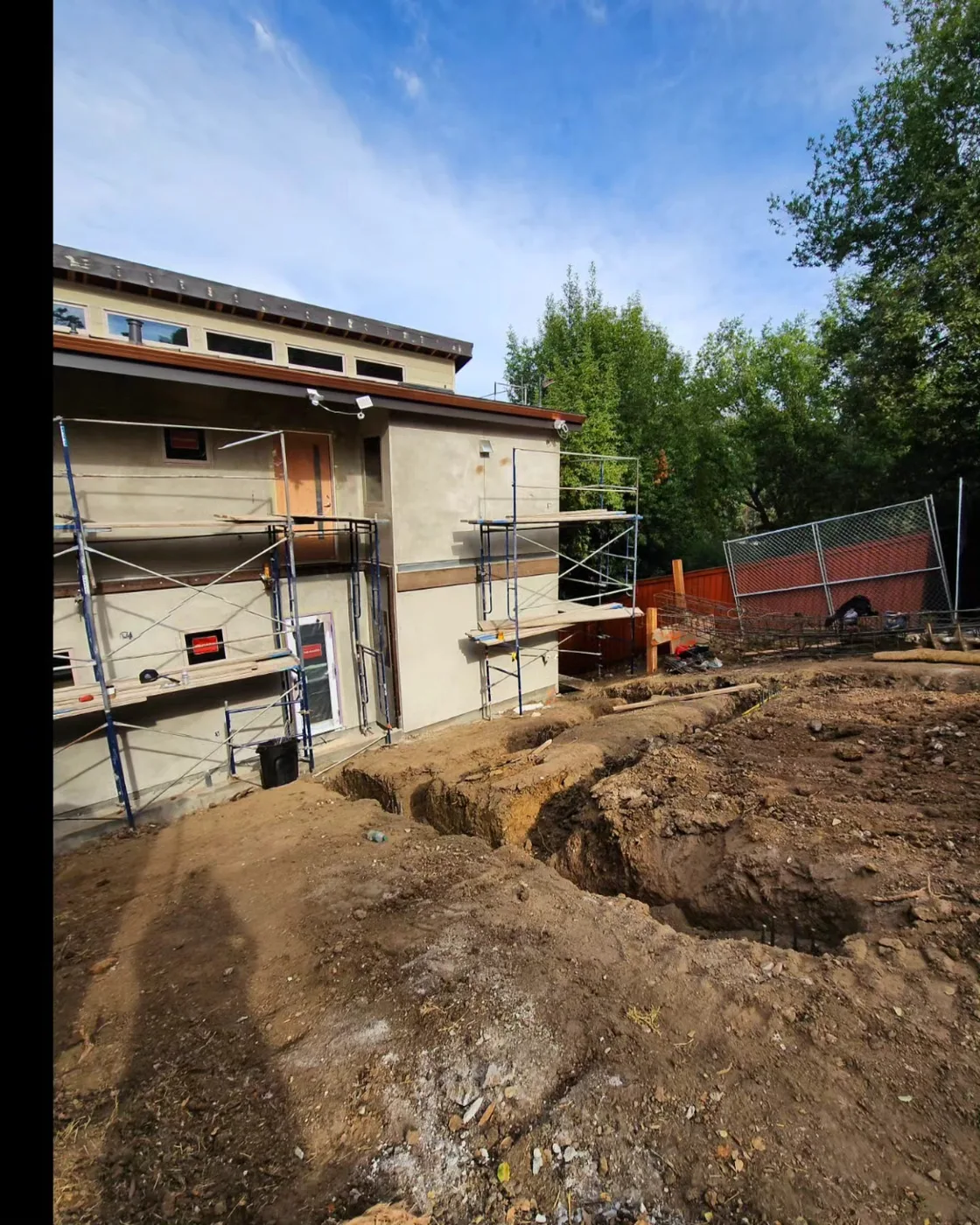 Excavated footing trenches with the scaffolded home behind — Richmond Bridge Driveway, Richmond, CA