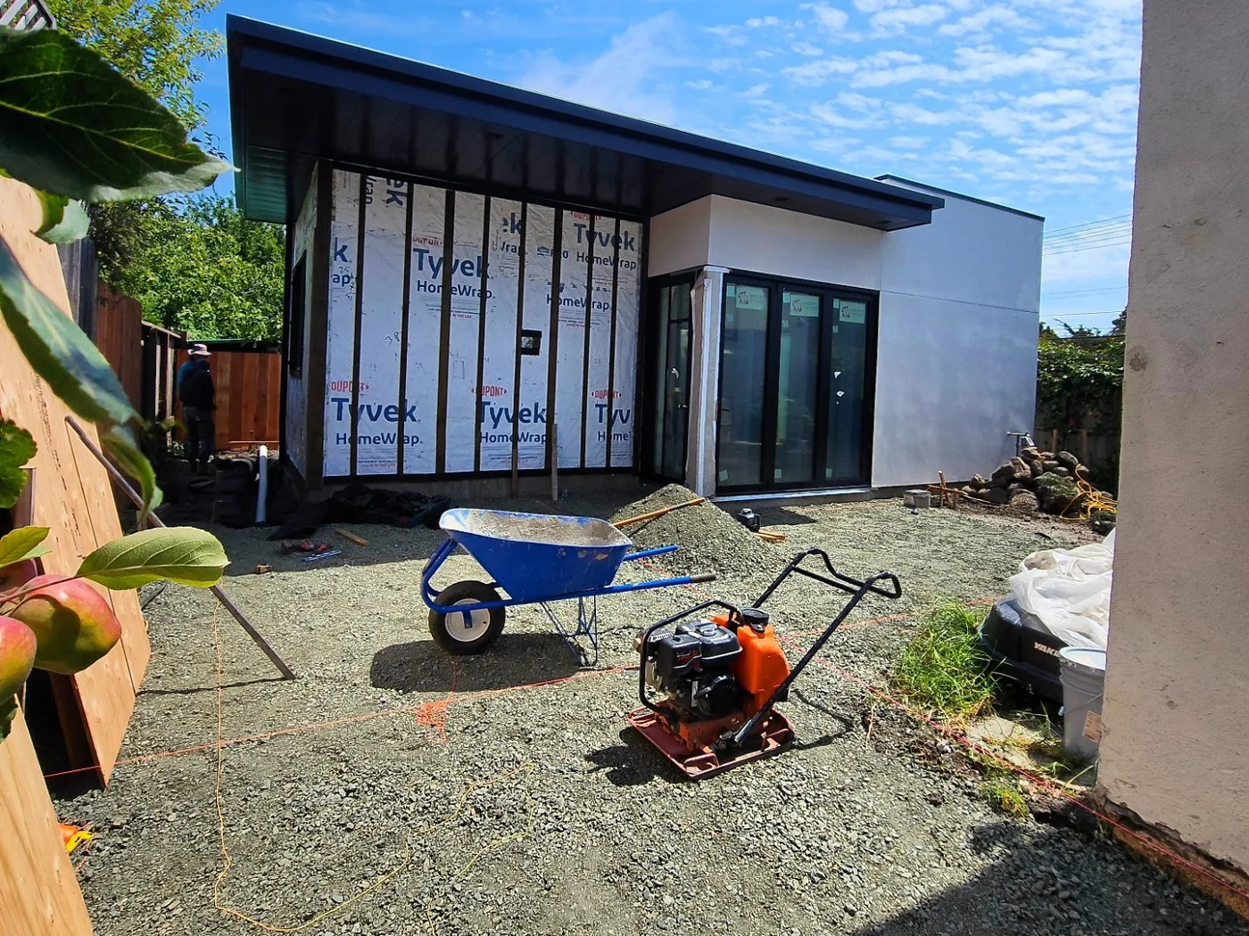 Compacting the gravel base with a plate compactor, the new home behind — Richmond Outdoor Patio, Richmond, CA