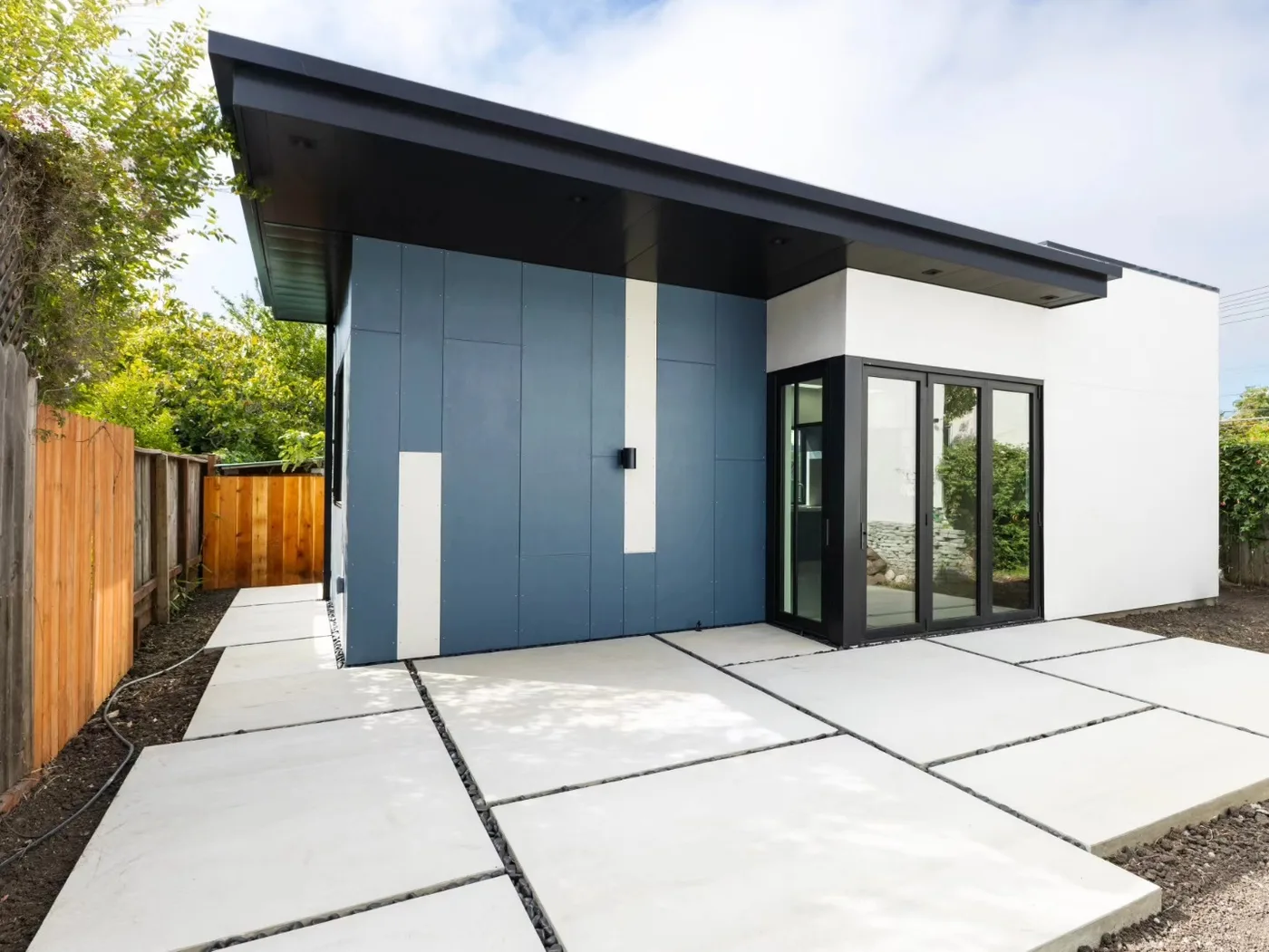 Finished large-format concrete panel patio wrapping the modern blue-and-white home — Richmond Outdoor Patio, Richmond, CA